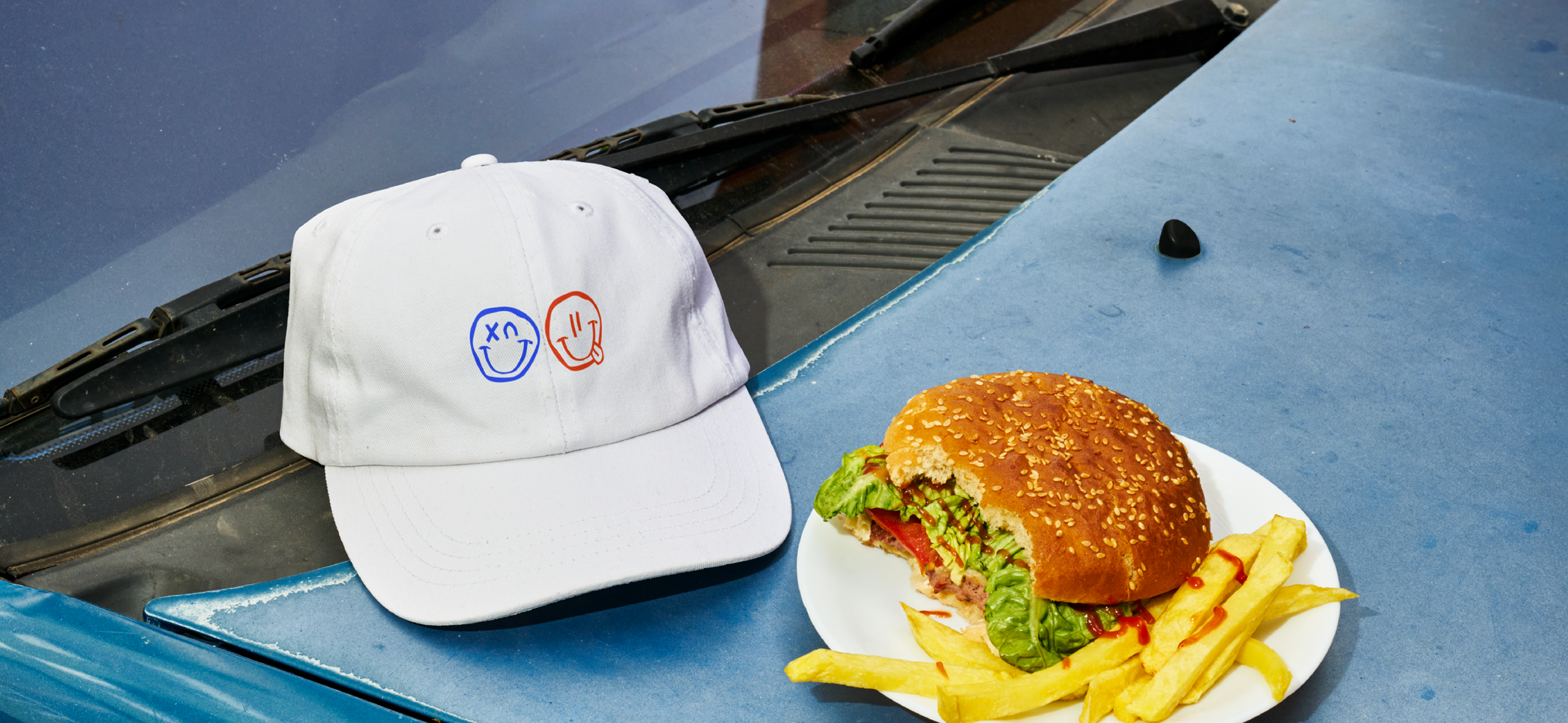 Gorra de marca y hamburguesa fotografiadas en proyecto de branding para Fernando García
